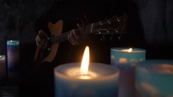 Play a healing guitar surrounded by candles